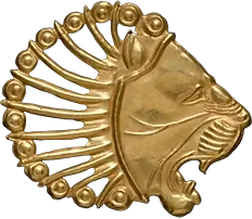 Photo of an appliqué in the shape of a lion's head, exhibited at the Metropolitan Museum of Art, showcasing its intricate craftsmanship and design.