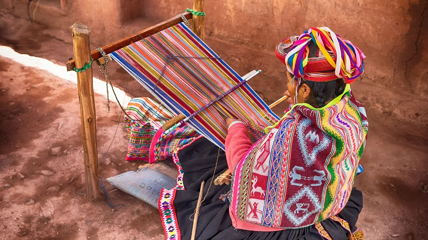 A photo capturing a woman engaged in the art of weaving.